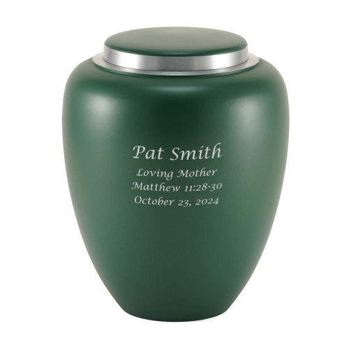 A matte emerald green memorial urn with a silver lid, featuring an engraved inscription. The urn has a smooth, modern design and is suitable for personalization.