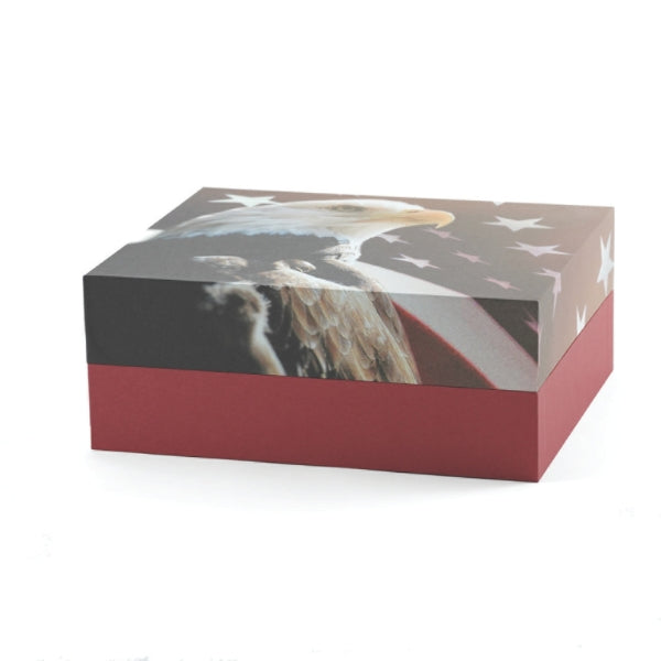 A rectangular eco-friendly memorial urn with a bold eagle and American flag design. The urn has a two-piece construction with a red base and a lid featuring a patriotic motif. Designed for scattering or burial. Engraving is not available.