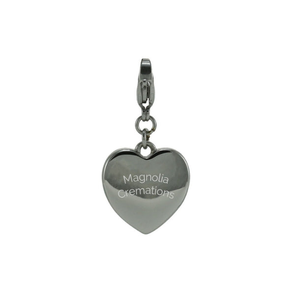 The Heart Keepsake Charm, available at Magnolia Cremations, is a silver-tone stainless steel charm with a polished finish. Designed to hold a small portion of ashes, this elegant piece offers the option for personalized engraving. The charm features a secure clasp, making it a meaningful addition to a bracelet or necklace.
