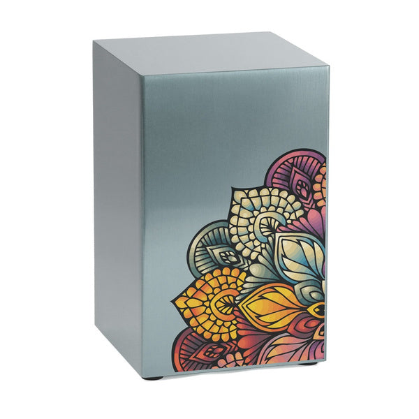 The Mandala in Pewter Companion Urn by Magnolia Cremations, featuring a vibrant mandala design on a sleek brushed pewter surface. The intricate floral pattern, blending deep reds, blues, and golds, symbolizes remembrance, love, and the interconnectedness of life. This contemporary cremation urn, part of the Life Canvas Series, offers personalization through custom engraving and can be displayed alone or as a meaningful pair.