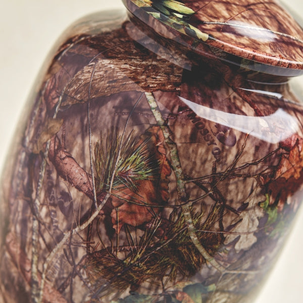 Close-up of the Magnolia Cremations Mossy Oak Camo Memorial Urn, showcasing its detailed Break-Up Country camouflage pattern. The realistic design features branches, leaves, and pine elements, making it a fitting tribute for those who cherished the great outdoors.