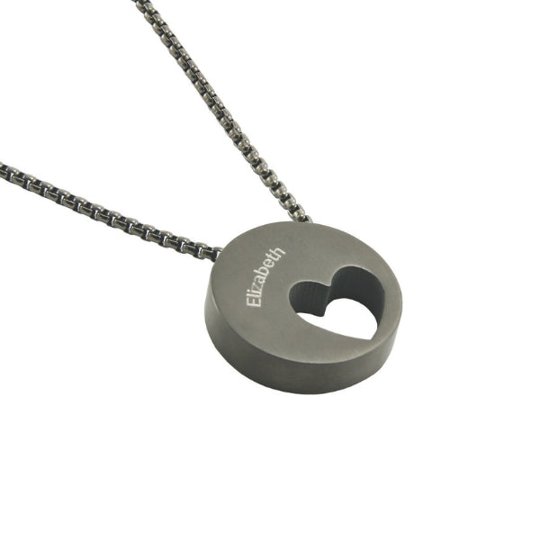 The Onyx Eternity Heart Memorial Necklace, available at Magnolia Cremations, is a sleek black stainless steel pendant featuring an off-centered heart cutout. Designed to hold a small portion of ashes, this piece offers a subtle yet meaningful tribute to a loved one. The pendant is paired with a matching 21-inch chain and includes an engraving option for personalization.