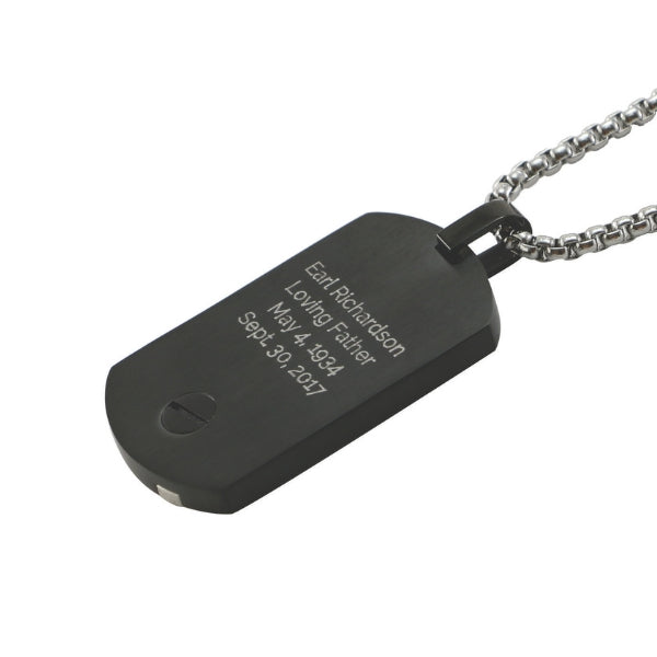 The Onyx Pendant Tag Necklace, available at Magnolia Cremations, is a sleek black stainless steel piece with a minimalist design. This pendant includes a discreet compartment for holding a small portion of ashes and features an engraving option for personalization. It comes with a matching 24-inch chain.