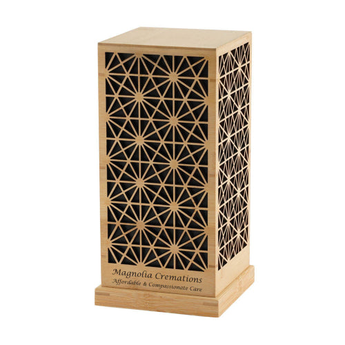 A rectangular Palazzo memorial urn available at Magnolia Cremations, crafted from bamboo and black MDF. The urn features an intricate geometric lattice pattern on the front and sides, creating a refined and elegant design. The base of the urn showcases an engraving of the Magnolia Cremations logo and tagline. Personalization is available for a custom tribute.