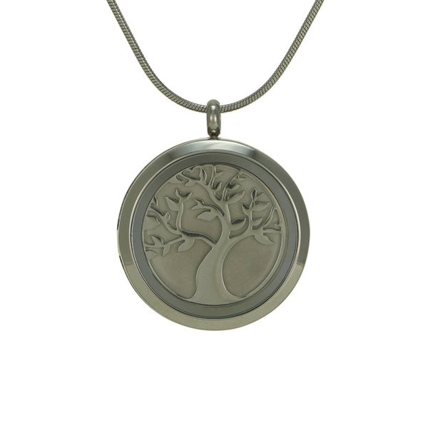 The Pewter Round Companion Tree Pendant Necklace, available at Magnolia Cremations, is shown with its symbolic tree insert in pewter. This stainless steel cremation pendant features a hinged back, allowing for the secure placement of a small portion of ashes. The tree design represents strength, resilience, and the continuation of life. Personalization options include custom engraving, and the pendant comes with a matching 19-inch chain with a lobster claw clasp.
