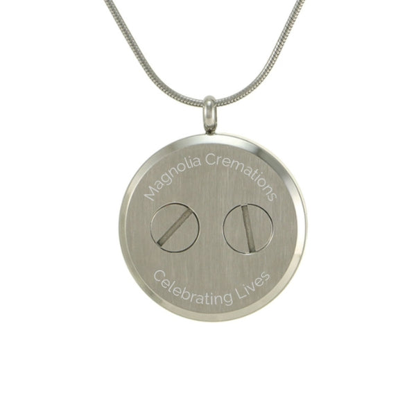 The Pewter Round Companion Tree Pendant Necklace, available at Magnolia Cremations, is displayed from the back, showing its secure dual-screw closure for holding a small portion of ashes. This stainless steel cremation pendant features an interchangeable tree insert, symbolizing strength and connection. Personalization options include custom engraving, and the pendant comes with a matching 19-inch chain with a lobster claw clasp.