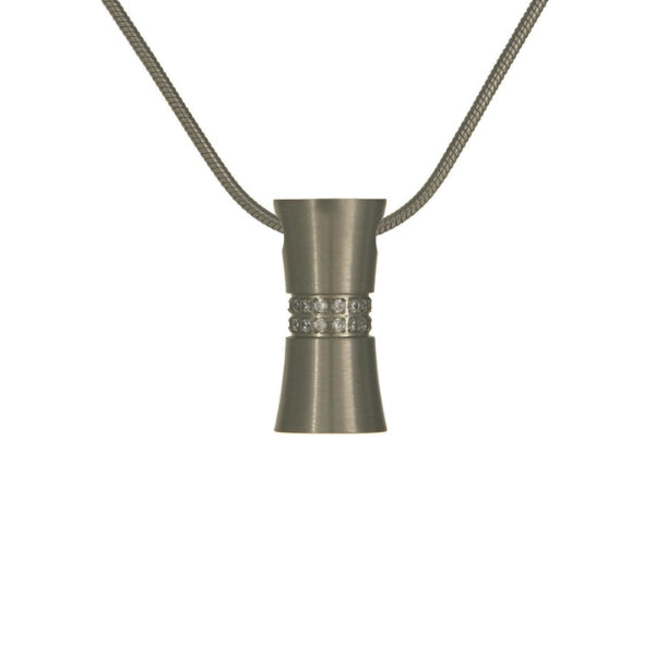 The Pewter Hourglass Memorial Necklace, available at Magnolia Cremations, is a refined stainless steel pendant with a brushed silver finish and shimmering cubic zirconia accents. Designed in an elegant hourglass shape, this necklace discreetly holds a nominal amount of ashes, keeping a loved one close. It comes with a matching 19-inch chain, offering a timeless and meaningful tribute.