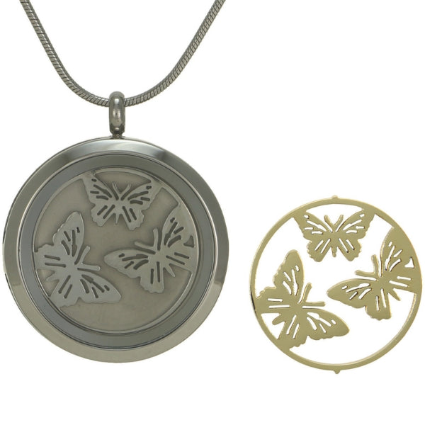 The Pewter Round Butterflies Pendant Necklace, available at Magnolia Cremations, is a circular stainless steel memorial pendant designed to hold a nominal amount of ashes in its secure compartment. This symbolic piece features interchangeable butterfly motif inserts—one in brushed pewter and the other in 14k-plated bronze—representing transformation and eternal memory. This remembrance necklace includes a matching 19-inch chain for a timeless and meaningful keepsake.