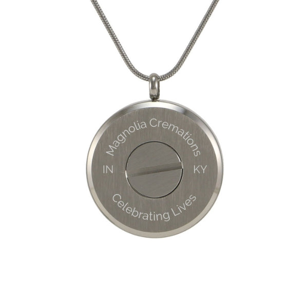 The Pewter Round Photo Glass Pendant Necklace, available at Magnolia Cremations, is displayed from the back, showcasing the secure compartment designed to hold a small portion of a loved one’s ashes. This stainless steel cremation pendant features a hinged glass front for easy photo placement, allowing for a deeply personal tribute. The design includes engraving options for customization and comes with a matching 19-inch chain and a lobster claw clasp.