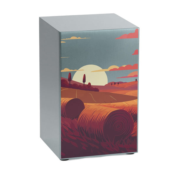 The Prairie Landscape in Pewter Memorial Urn, available at Magnolia Cremations, is a full-size, brushed stainless steel urn featuring a serene prairie scene at sunset. The artwork showcases rolling fields, hay bales, and a glowing sun against a soft blue sky, blending warm and earthy tones. The urn’s smooth, metallic finish enhances the vibrancy of the design. Personalization is available with custom engraving options.