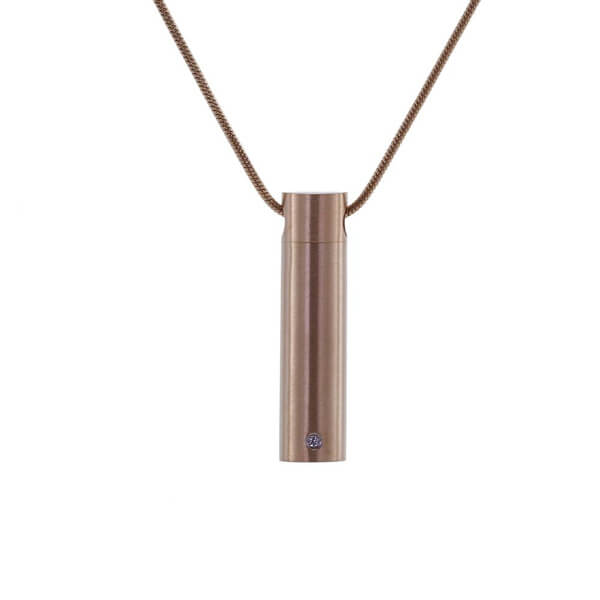 The Rose Cylinder with Cubic Zirconia Necklace, available at Magnolia Cremations, is a refined and meaningful keepsake designed to hold a small portion of a loved one’s ashes. This stainless steel pendant features a sleek rose gold finish and is accented with a single cubic zirconia stone for a touch of elegance. The cylindrical shape offers a discreet and timeless design. Personal engraving is available, and the piece includes a matching chain for effortless wear.