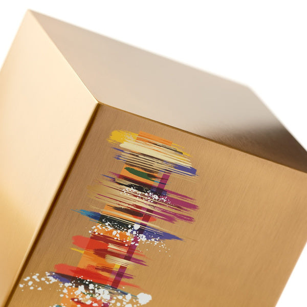 A close-up of The Artist in Bronze Memorial Urn, available at Magnolia Cremations, highlighting its brushed bronze finish and striking abstract design. The vibrant artwork features expressive brushstrokes in red, orange, purple, and blue, with splashes of white for a dynamic, artistic effect. The urn’s smooth metallic surface reflects light, emphasizing its contemporary style and refined craftsmanship.