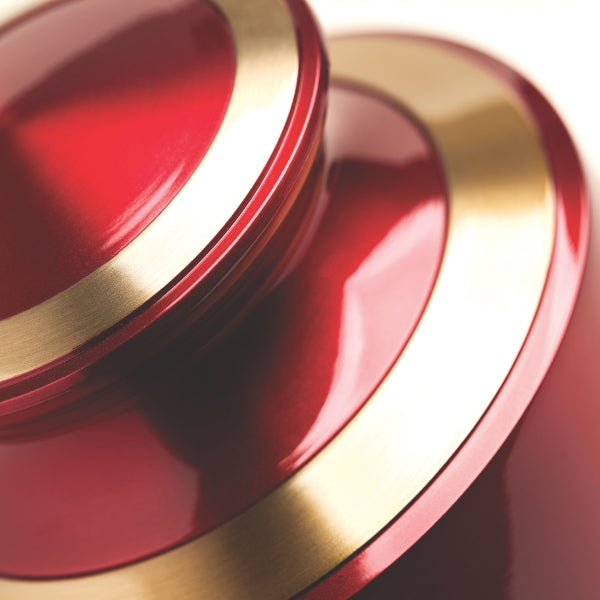 A close-up of the Trinity Crimson Memorial Urn, available at Magnolia Cremations, highlighting its deep red high-gloss finish and elegant gold accents. The image captures the urn's smooth curves and reflective surface, showcasing its quality craftsmanship.