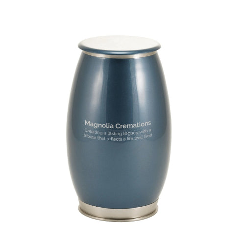 The Windsong Coral Memorial Urn, available at Magnolia Cremations, shown in its deep blue high-gloss finish with silver-tone accents. The urn has a smooth, modern silhouette with a polished stainless steel base and lid. A soft engraving is displayed on the front, and the urn appears without its removable coral accent. The reflective surface enhances its elegant and contemporary design.