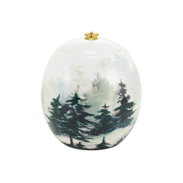 Round ceramic memorial cremation urn with forest design on a white background