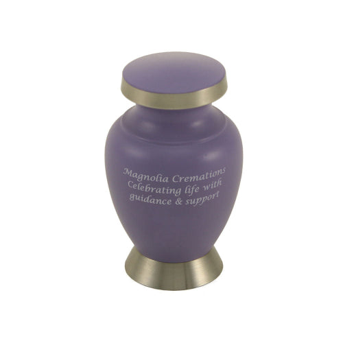 The Aria Butterfly Keepsake Urn from Magnolia Cremations features a matte lavender finish with a brushed silver butterfly accent. Its compact design includes a rounded body, flared base, and silver-trimmed lid. Engraving is available.