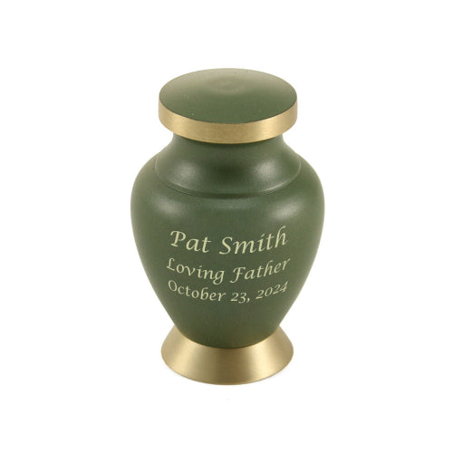 The Aria Tree of Life Keepsake Urn, available at Magnolia Cremations, in matte green with gold-tone accents, featuring an engraved personalized inscription. This small urn is designed to hold a portion of a loved one’s ashes, allowing multiple family members to keep a cherished remembrance. Crafted from brass, it offers durability and elegance in a compact size.