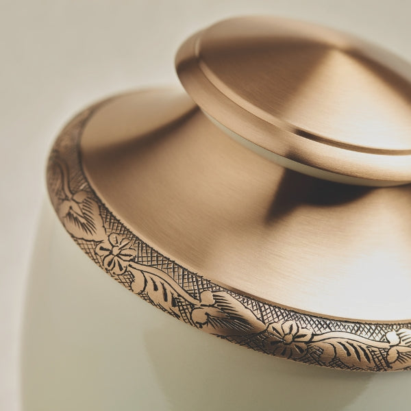 Brass cremation urn with a pearl white finish and hand-etched floral details. Artisan Pearl by Terrybear.