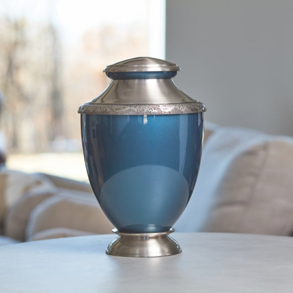 Indigo Artisan cremation urn with silver detailing, displayed in a home setting.