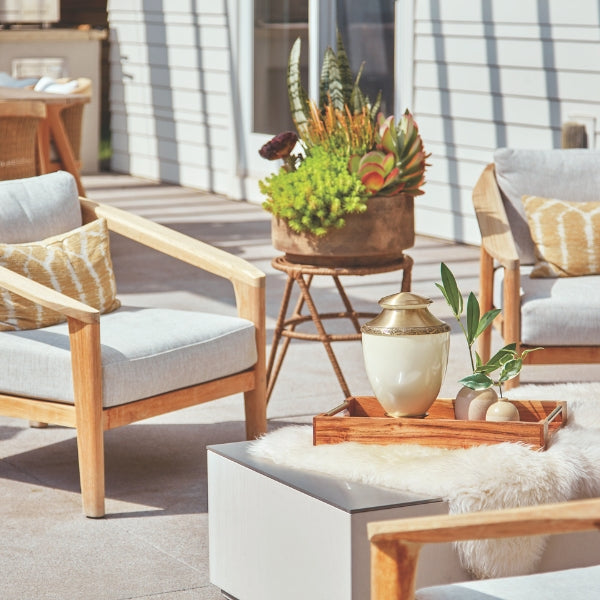 Elegant Artisan cremation urn displayed on an outdoor patio with natural light and greenery.