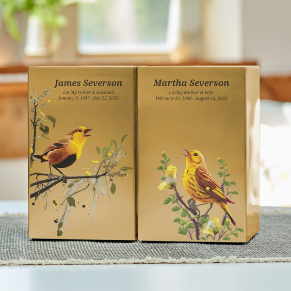 Pair of companion urns designed to be displayed together, each featuring a unique bird illustration and personalized engraving.