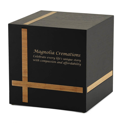 Bristol Ebony/Bamboo Extra-Large Cremation Urn with a custom engraving. The urn has a sleek cube design, made of medium-density fiberboard (MDF) with an ebony finish and contrasting bamboo inlays in a geometric pattern. Designed for home display, it includes a sliding bottom panel secured with a screw. Personalization with engraving is available. 245 cubic inch capacity.