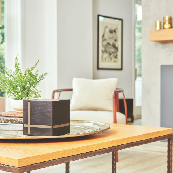 Bristol Ebony/Gloss Gray Extra-Large Cremation Urn displayed on a decorative tray in a modern living room. The urn features a matte black MDF finish with sleek gloss gray inlays in a geometric pattern. Designed for home display. 245 cubic inch capacity.
