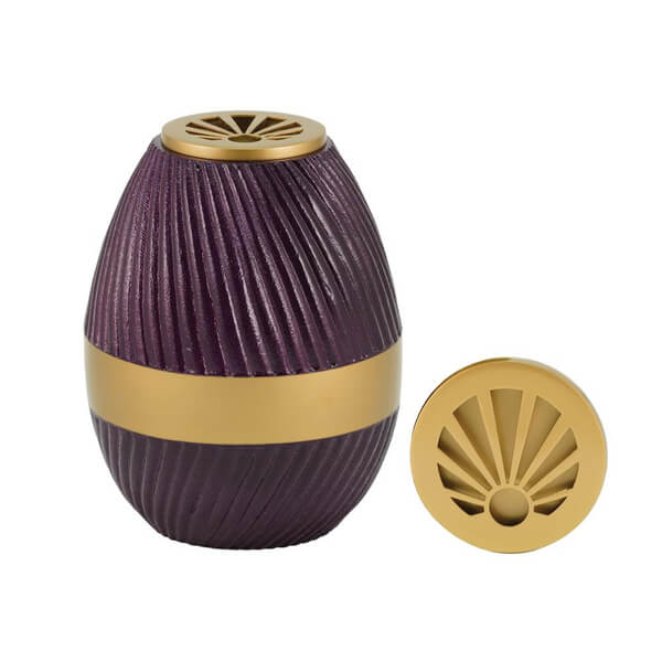 A purple, egg-shaped scattering urn with a ribbed texture and a wide gold band around the middle. The urn features a decorative gold lid with a sunburst-style cutout, which is shown both on and removed from the urn. The design allows it to be used as a vase as well.