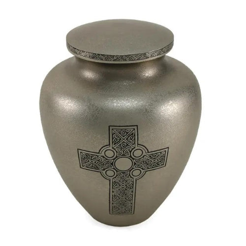 Celtic Cross Full-Size Cremation Urn. A traditional brass urn with a textured silver finish, featuring an engraved Celtic Cross design symbolizing eternal love and faith. The lid is adorned with an intricate Celtic pattern. 200 cubic inch capacity.