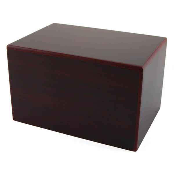 A cherry wood cremation urn with smooth, glossy surfaces and slightly rounded edges. 
