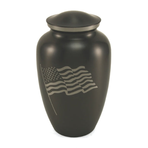 Classic Flag Full-Size Cremation Urn. A traditional stainless-steel urn with a sleek black finish, featuring a silver engraving of the American flag waving. Designed to honor a patriot, this urn can be personalized with custom engraving. 200 cubic inch capacity.