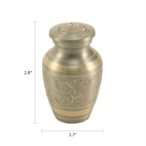 The Classic Platinum Keepsake Urn, offered by Magnolia Cremations, is a small, elegant urn with a brushed silver finish and gold-tone accents. Delicate floral engravings wrap around its surface, creating a timeless and sophisticated tribute. Measuring 2.8 inches tall, this keepsake urn holds a small portion of ashes, allowing families to cherish and share the memory of their loved one.