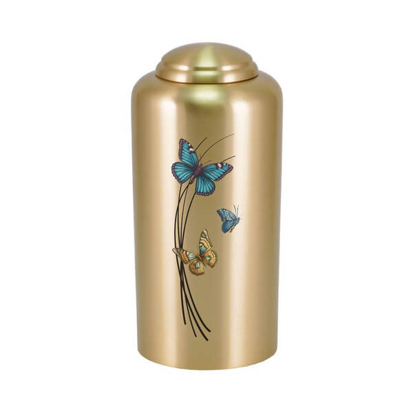 Gold-colored cremation urn with a domed lid, featuring a design of three colorful butterflies—blue, orange, and teal—fluttering around black curved lines resembling tall grass.