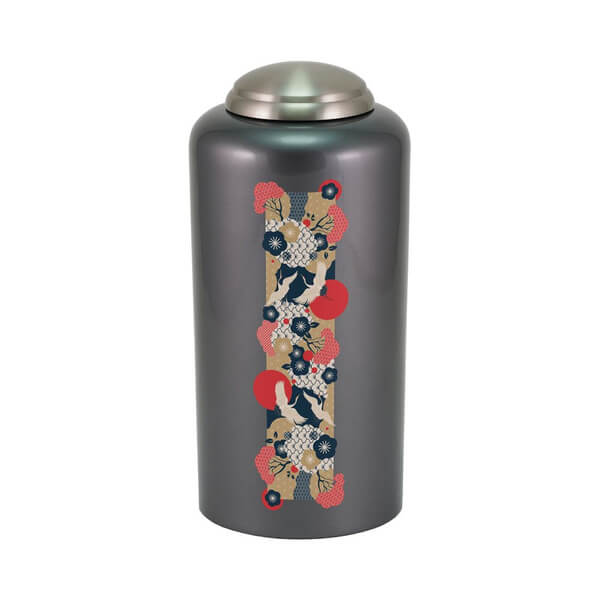 Dark gray cremation urn with a metallic lid, featuring a vertical decorative strip with a Japanese-style crane design, red sun motifs, and floral patterns in red, navy blue, white, and beige.