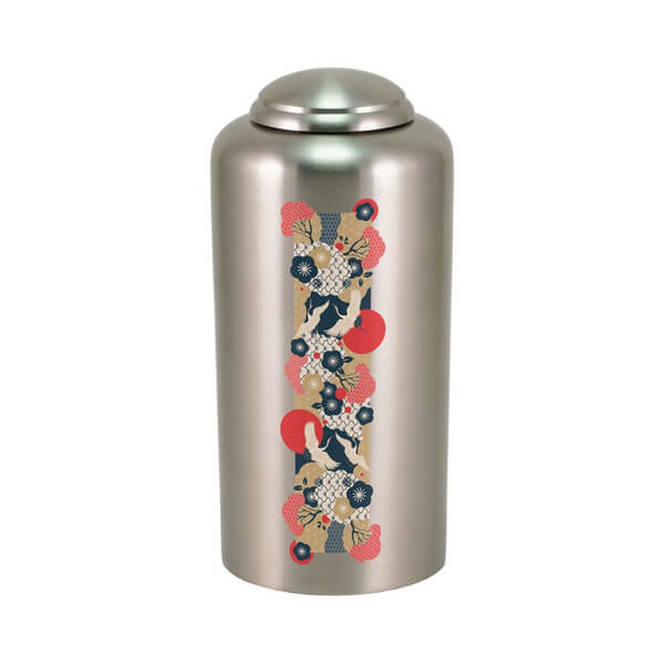 Silver cremation urn with a vertical decorative band featuring a traditional Japanese-style design, including cranes, red sun motifs, and floral patterns in red, navy blue, cream, and gold tones.