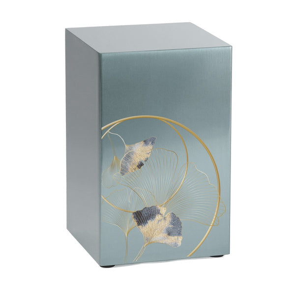 A rectangular silver-colored memorial urn with a brushed stainless steel finish. The front features an elegant ginkgo leaf design, with gold outlines and textured leaves in shades of blue and gold. The urn has a modern, minimalist shape, designed for individual use or as part of a companion set.