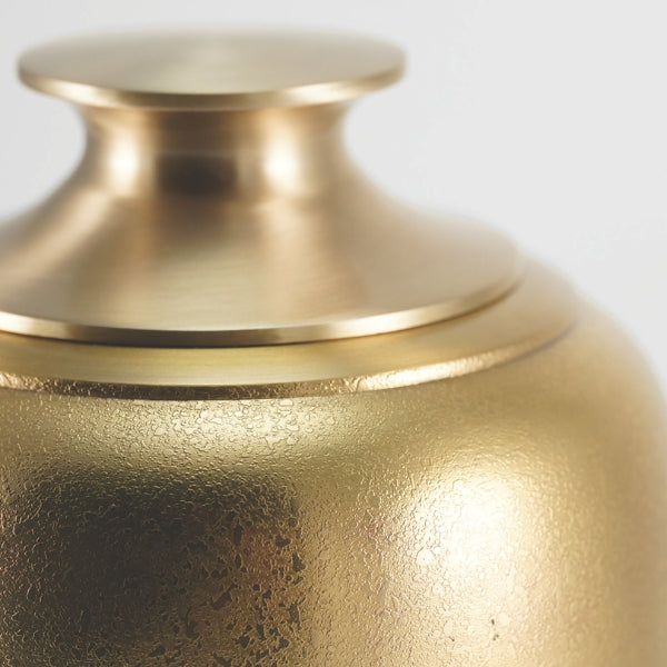 A close-up of the Luna Textured Bronze Memorial Urn, showcasing its elegant brushed gold finish and subtle textured detailing. The urn's gently curved shape and polished lid add a refined touch, making it a timeless tribute to a loved one.