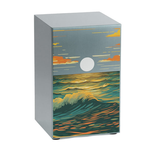 A contemporary stainless steel memorial urn in a pewter-toned finish, featuring a striking ocean landscape design. The artwork depicts rolling waves illuminated by a setting sun, with a sky painted in warm hues of gold, orange, and blue. This urn is part of the Life Canvas Series, offering a meaningful tribute through art. Available at Magnolia Cremations, with optional engraving for personalization.