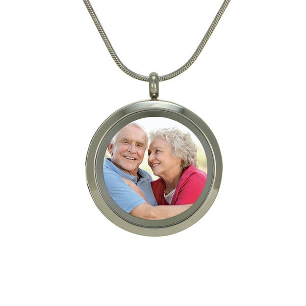 Pewter round memorial locket with glass photo cover and hinged opening.