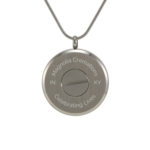 The Pewter Round Tree Pendant Necklace, available at Magnolia Cremations, is shown from the back, highlighting the secure compartment designed to hold a small portion of ashes. This stainless steel cremation pendant features a screw closure for safekeeping and offers engraving options for personalization. The design is completed with a matching 19-inch chain for a meaningful and wearable tribute.