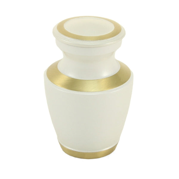 The Trinity Pearl Keepsake Urn, available at Magnolia Cremations, is a small, elegant urn with a high-gloss creamy white finish and gold-tone accents on the lid, rim, and base. Crafted from brass, this keepsake urn offers a refined and contemporary tribute. Personalization options are available, making it a meaningful way for loved ones to share in remembrance.