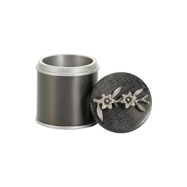 Dark metallic keepsake urn with a brushed silver interior and matching removable lid placed beside it, featuring two sculpted silver flowers with leaves on the top.