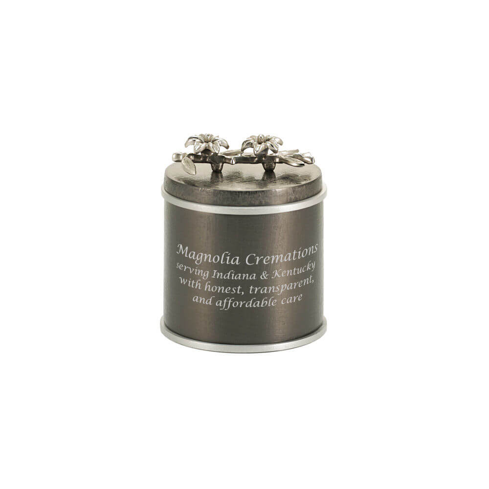 Dark metallic keepsake urn with silver flower embellishments on the lid; optional engraving is shown on the front.