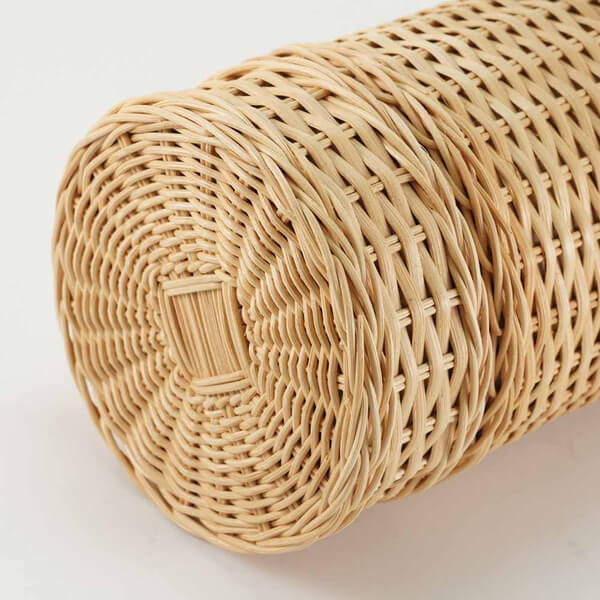 Close-up view of the top of a cylindrical rattan scattering urn, showing detailed natural woven texture and craftsmanship.